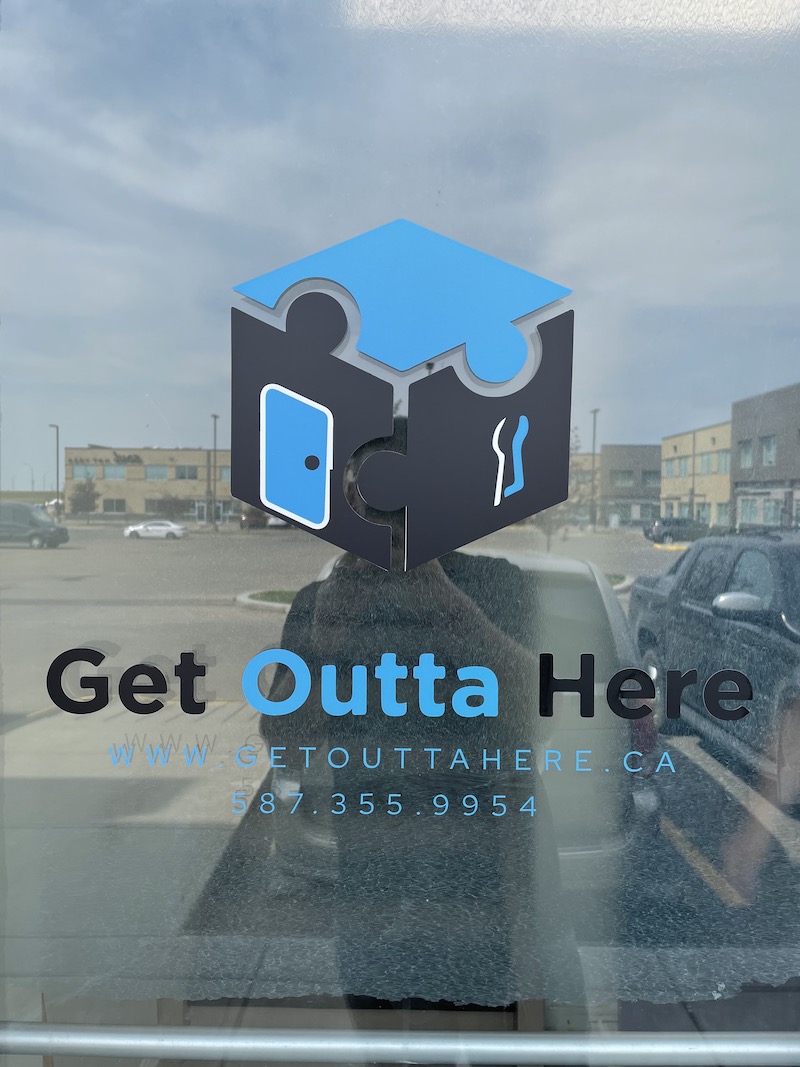 Logo for Get Outta Here escape rooms as seen on the building door.