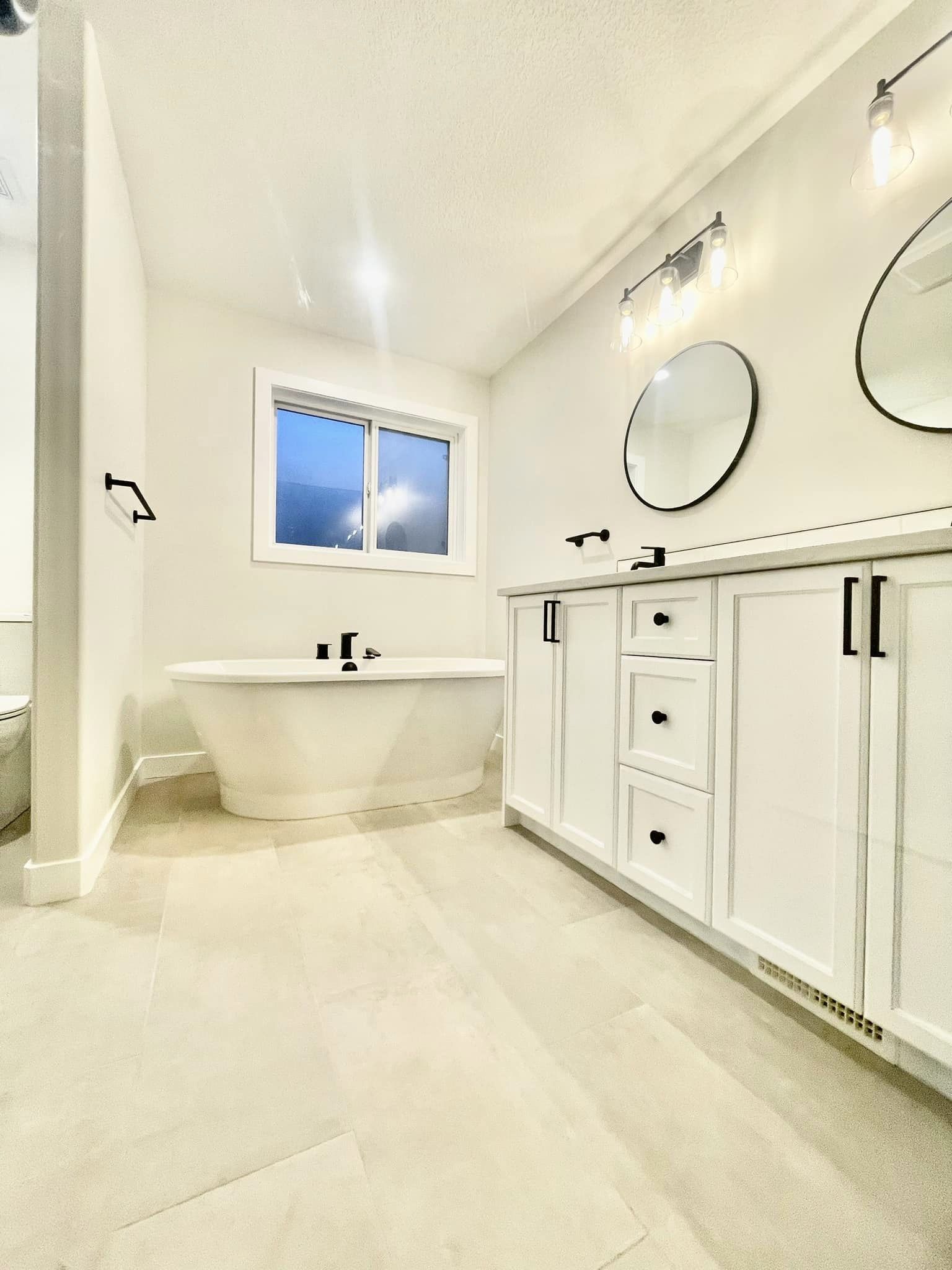 Modern bathroom with dual mirror/sink and freestanding bathtub.